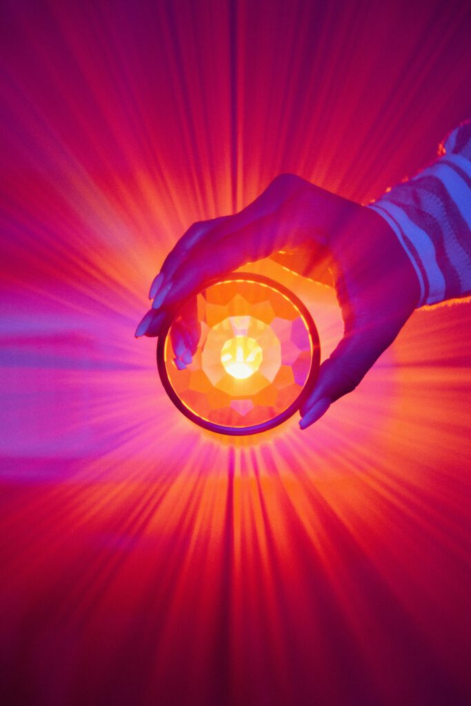 Cristal cogido por una mano que refleja un espectro de luces que simula el espectro autista.